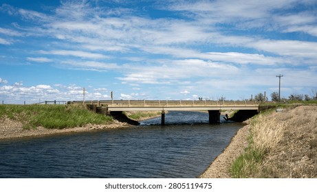 A small bridge spanning a ditch, often used as a road in rural areas.