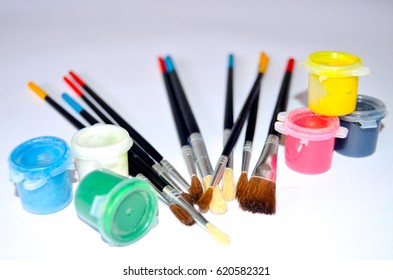 Small brushes and buckets of paint