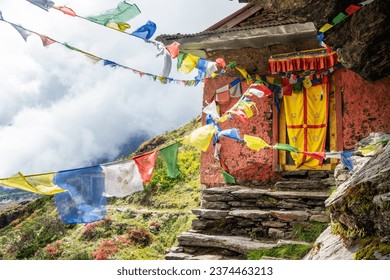 Small Buddhist monastery decorated with multicolored Tibetan prayer flags with mantras on Kothe - Thangnak climbing Mera peak route in Makalu Barun National Park. Peaceful and sacred place photo.