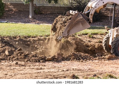 Small Bulldozer Digging In Yard For Pool Installation.