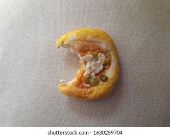 A Small Burger That Has Been Bitten On A Gray Background. Top View Close Up Detail