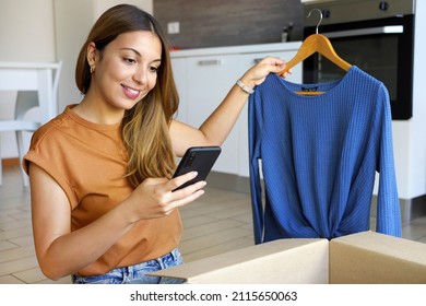 Small business entrepreneur. Stylish business owner woman using smartphone app to sell clothing online.