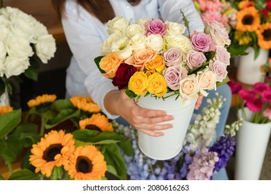 Small business. Female florist unfocused in flower shop. Floral design studio, making decorations and arrangements. Flowers delivery, creating order.