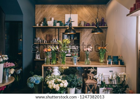 Small business. Flower shop interior. Floral design studio, decorations and arrangements and gifts. Flowers delivery service and sale of home plants in pots, wooden showcase, nobody.