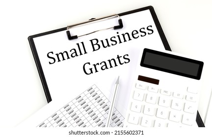 SMALL BUSINESS GRANTS Text On Folder With Chart And Calculator On A White Background