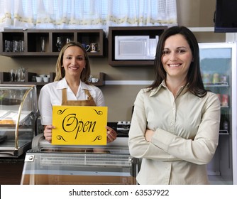 Small business: Happy owner of a cafe showing open sign - Powered by Shutterstock