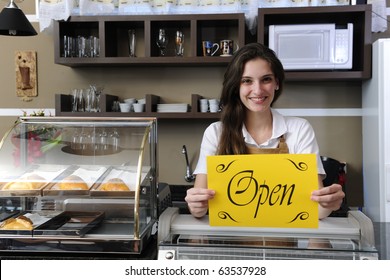 Small Business: Happy Owner Or Waitress Of A Cafe Showing Open Sign