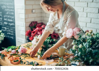 Small business. Male florist unfocused in flower shop. Floral design studio, making decorations and arrangements. Flowers delivery, creating order - Shutterstock ID 705012436