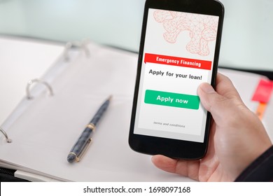 Small Business Owner Applying For Emergency Financing Using A Mobile Phone.