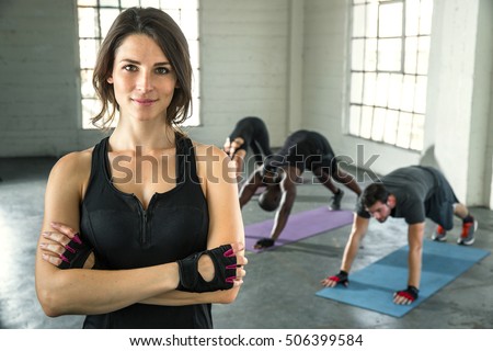 Small business owner of athletic gym smiling trainer instructor posing for a portrait with students
