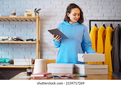 Small Business Owner, Entrepreneur, Seller Using Tablet Checking Ecommerce Clothing Store Orders. Online Sales.