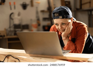 Small business owner female carpenter in her workshop using laptop to order material. Small business concept - Powered by Shutterstock