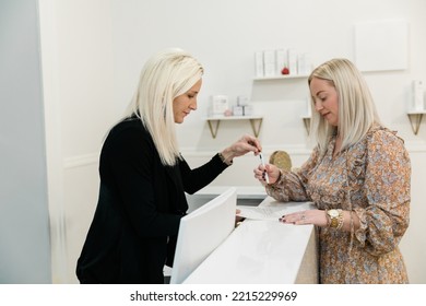 A Small Business Owner Helping A Client At A Wellness Spa At The Front Desk.