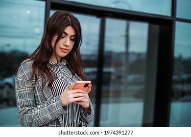 Small Business Owner Office Worker Woman Standing Outside Building With Mobile Phone Make Selfie Video Chat. Female Mexican Latin American Successful Executive Girl Hold Gadget
