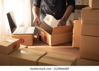 Small business owner packing in the cardbox at workplace. Cropped shot of man preparing a parcel for delivery at online selling business office. Ecommerce drop shipping shipment service concept.