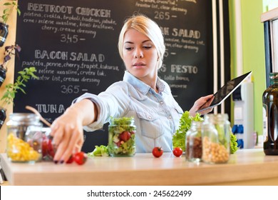 Small Business Owner Reading The Recipe On A Digital Tablet