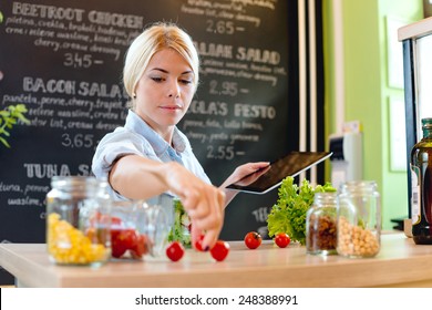 Small Business Owner Reading The Recipe On A Digital Tablet