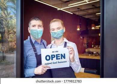 Small Business Owner Smiling While Holding Sign For Reopening Of Restaurant After Lockdown Quarantine Due To Coronavirus - Entrepeneur Open Coffee Shop Activity To Support Local Businesses.