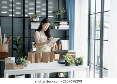 Small Business Owner Using Tablet to Check Orders and Prepare Products for Sale.