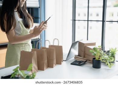 Small Business Owner Using Tablet to Check Orders and Prepare Products for Sale.