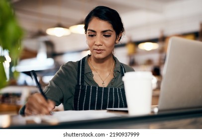 Small Business Owner Working On A Budget In Her Coffee Shop And Writing A List Of Stock To Order. Serious Female Entrepreneur Developing A Growth Strategy For Her Cafe Startup