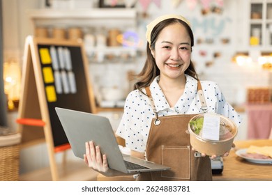 Los Pequeños dueños de negocios están vendiendo. El dueño asiático de la tienda de pasteles de panadería disfruta publicando una foto y revisa su pastel en las redes sociales o en línea de marketing en streaming para publicar publicidad de negocios Pequeños.