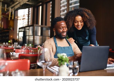 Small business owners using laptop in restaurant