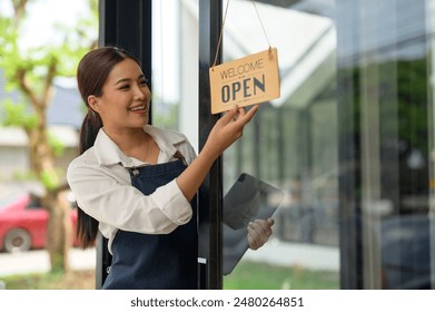 Small business owners who are successful in business Young Asian woman standing with a sign Opening a coffee shop, independent business, female barista, startup idea, SME business. - Powered by Shutterstock