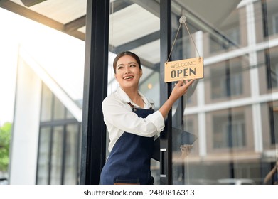 Small business owners who are successful in business Young Asian woman standing with a sign Opening a coffee shop, independent business, female barista, startup idea, SME business. - Powered by Shutterstock