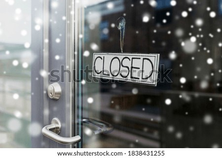 small business, pandemic and service concept - glass door of closed shop or office in winter over snow