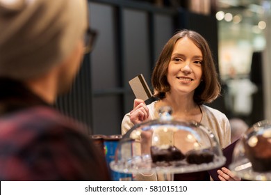 Small Business, Payment, People And Service Concept - Happy Woman With Credit Card Buying Cakes At Vegan Cafe Or Coffee Shop