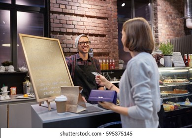 Small Business, Payment, People And Service Concept - Happy Barman And Woman Paying With Credit Card At Cafe