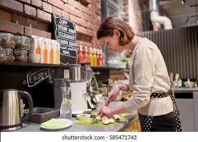 Small Business, People And Service Concept - Happy Woman Or Barmaid Cooking At Vegan Cafe