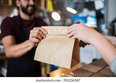 small business, people and service concept - man or bartender serving customer at coffee shop - Powered by Shutterstock