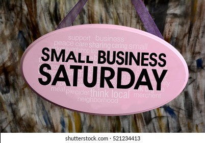 Small Business Saturday Sign Hanging On Pink Sign.