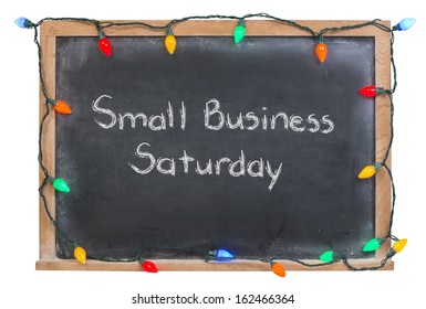 Small Business Saturday written in white chalk on a black chalkboard surrounded by festive colorful lights isolated on white - Powered by Shutterstock