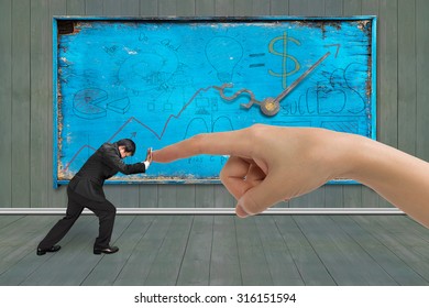 Small Businessman Pushing Against Big Hand Forefinger, With Old Weathered Noticeboard.