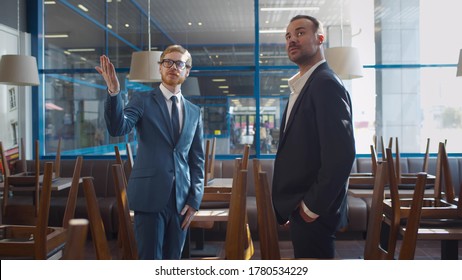 Small Businessman Renting Or Buying Space For Coffee Shop Or Restaurant. Real Estate Agent And Entrepreneur In Commercial Property Shaking Hands After Successful Deal