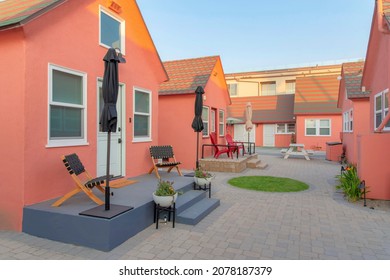 Small Cabins At Oceanside, California With Lounge Chairs And Umbrellas At The Doorstep