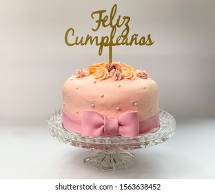 Small cake birthday with “happy birthday” sign in spanish