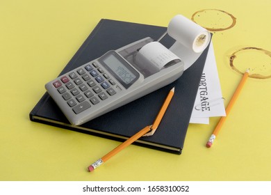 A Small Calculator A Notebook Of Receipts And A Pencil Broken In Frustration On A Coffee Stained Green Desk Blotter