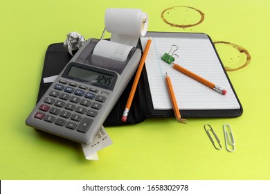 A Small Calculator With A Paper Tape And Pencils Broken In Frustration On A Coffee Stained Green Desk Blotter