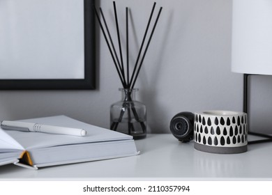 Small Camera Hidden Among Home Stuff On White Table Indoors