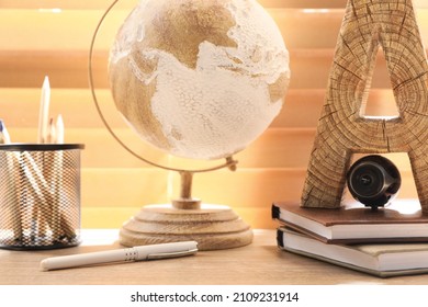 Small Camera Hidden Among Stationery On Wooden Desk Against Window Indoors