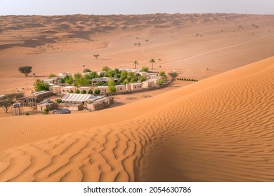 Small camp with trees in the middle of Arabian desert. Oasis in Wahiba Sands, Oman. Hot day in the dunes of Arabian peninsula - Powered by Shutterstock