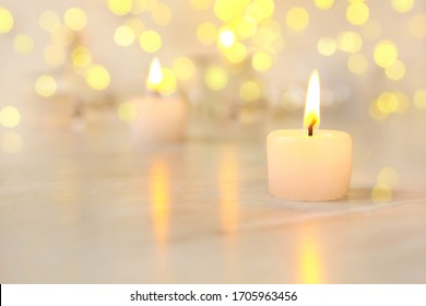 Small Candle With Light Yellow Spots On Light Background