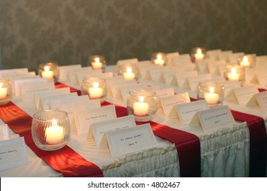 small candles lighting placecards for guests at a wedding reception