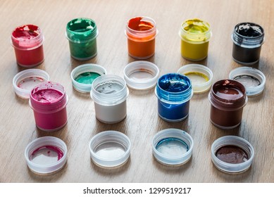 small cans of colorful gouache paint on the whole frame. Horizontal frame - Shutterstock ID 1299519217