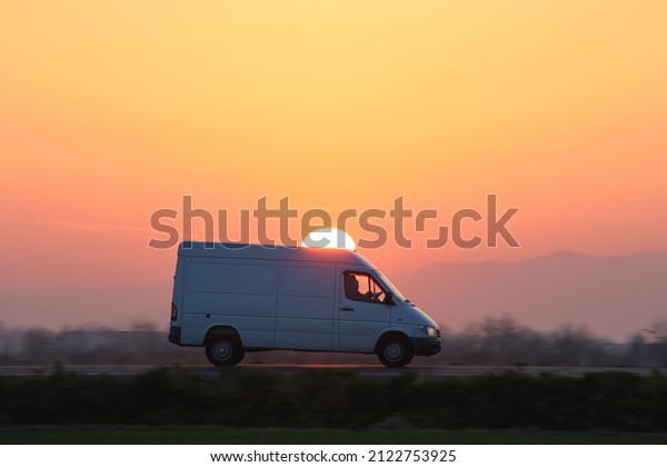 Small cargo van driving on highway\
hauling goods. Delivery transportation and logistics\
concept