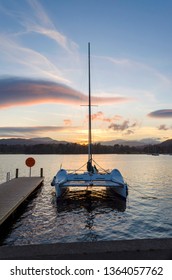 Small Catamaran At Sunset On Lake Windermere 
